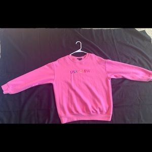 A pink “USA CREW” crew neck
